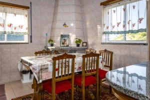 a dining room with a table and chairs and windows at Fraga Douro House, Douro Valley in Resende