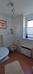 baño blanco con aseo y ventana en Ferienwohnung Weise, en Grillenberg