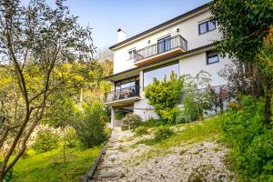 an exterior view of a white house with trees at Fraga Douro House, Douro Valley in Resende
