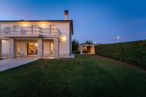 a house with a large lawn in front of it at Villa Bincila for 12 people near Poreč with sea view & beautiful garden in Labinci