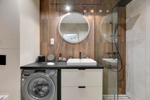 a bathroom with a washing machine and a sink at Monte Cassino Apartments by Blue Mandarin in Sopot