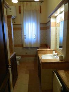 een badkamer met een wastafel, een toilet en een raam bij Podere Giunchi in Marsala