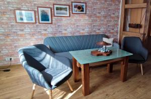 a living room with a blue couch and a table at Ferienwohnung Weise in Grillenberg