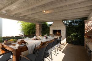 a table and chairs on a patio with a fireplace at Villa Bincila for 12 people near Poreč with sea view & beautiful garden in Labinci