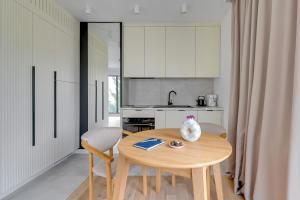 a kitchen with a table and chairs and a kitchen with white cabinets at Monte Cassino Apartments by Blue Mandarin in Sopot