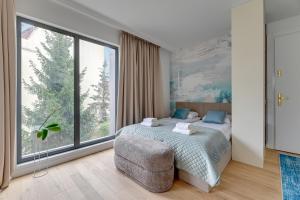 a bedroom with a bed and a large window at Monte Cassino Apartments by Blue Mandarin in Sopot