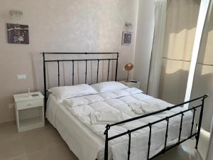 1 dormitorio con 1 cama con sábanas blancas en B&B Villa Eraclea, en Villaggio Mosè
