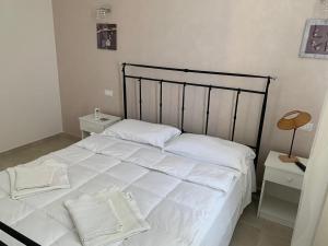 ヴィッラッジョ・モセにあるB&B Villa Eracleaのベッドルーム1室(白い大型ベッド1台、ナイトスタンド2台付)