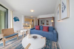a living room with a blue couch and a table at at Water's Edge Resort in Airlie Beach