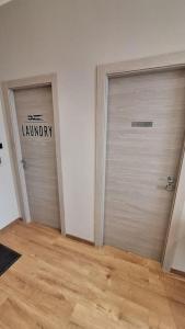 2 puertas metálicas de garaje en una habitación con suelo de madera en Suite Room Funai Silver, en Trapani