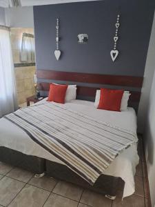 een slaapkamer met een groot bed met harten aan de muur bij Honey Bee Guesthouse in Rustenburg