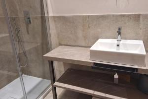 y baño con lavabo blanco y ducha. en Suite Room Funai Silver, en Trapani
