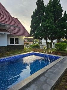 a swimming pool in front of a house at Villa Nesa Puncak Cipanas in Cipanas +10 photos