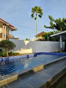 a swimming pool in a yard next to a house at Villa Nesa in Cipanas