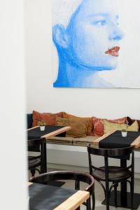 Embrace Sicily Guest House في نوتو: غرفة بطاولات واريكة عليها لوحة