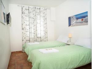 two beds in a room with green sheets at Affittacamere di Andrea Bertolino Argelato in Argelato