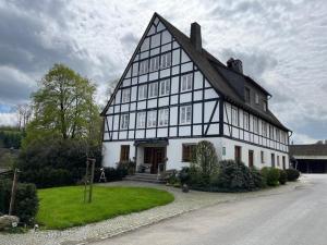 a large black and white building with a yard at Ferienhof Kotthoff am Hennesee in Meschede