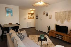 a living room with a couch and a flat screen tv at T3, à 5 min à pied du lac Annecy in Duingt