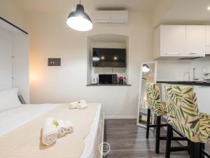 Habitación con cama, sillas y cocina. en Downtown Gem 1, en Cagliari