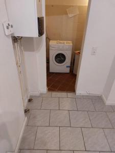 baño pequeño con lavadora y suelo de baldosa en Koala-1-5-Personen en Brunsbüttel
