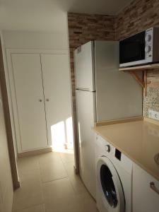 a kitchen with a refrigerator and a washing machine at Casa Correos in Medina Sidonia