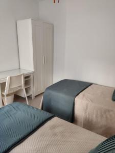 a bedroom with two beds and a desk and a desk at Casa Correos in Medina Sidonia