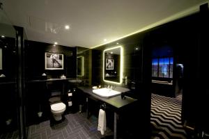 a black bathroom with a sink and a toilet at Hotel Gotham in Manchester