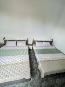 two beds sitting next to each other in a bedroom at HATY MOTEL & COFFEE in Pleiku