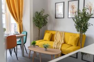 sala de estar con sofá amarillo y mesa en Open Mind Property - Cosy Flat in Southsea en Portsmouth