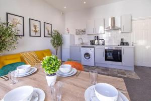 una cocina con una mesa con platos. en Open Mind Property - Cosy Flat in Southsea en Portsmouth