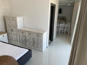 ein Wohnzimmer mit weißen Schränken und ein Esszimmer in der Unterkunft Beach Rooms Roberta in Mamaia