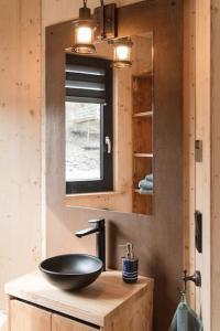 a bathroom with a sink and a mirror at Luxus-Hausboot DIVA mit Kamin in Hamburg