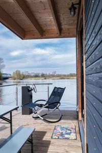 a chair sitting on a dock next to the water at Luxus-Hausboot DIVA mit Kamin in Hamburg