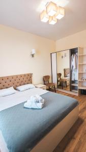 um quarto com uma cama grande e um cobertor azul em GG ApartHotel em Batumi