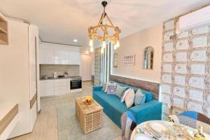 un soggiorno con divano blu e una cucina di Apartament Nety House Alezzi a Mamaia Nord - Năvodari