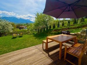 una terrazza in legno con tavolo e ombrellone di Casa Aluna Duo a Sohodol