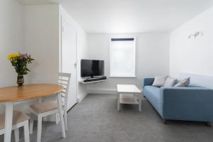 a living room with a blue couch and a table at Beautiful 1 bedroom ground floor new apartment in old Cornwall in St. Just