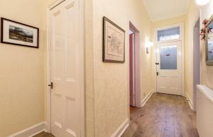 a hallway with a door and two pictures on the wall at Palm Tree Apartment- Period Home with Cat in Edinburgh