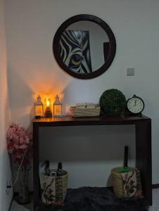 een tafel met een spiegel en een klok aan een muur bij Jenty Homes in Arusha