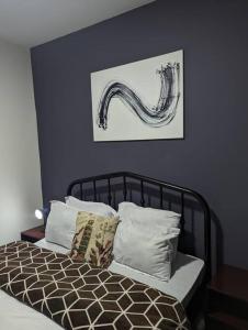een slaapkamer met een bed met een schilderij aan de muur bij Jenty Homes in Arusha