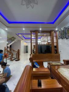 eine Lobby mit einem TV und die Leute auf dem Boden in der Unterkunft Homestay Sea View Ông Hoành 