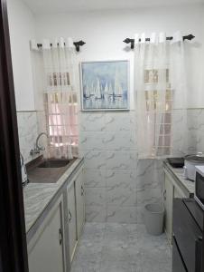 uma cozinha branca com um lavatório e uma janela em Jenty Homes em Arusha