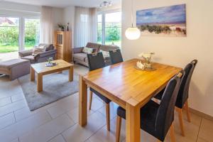 ドルヌマージールにあるFerienhaus Inselrosenのリビングルーム(木製テーブル、椅子付)