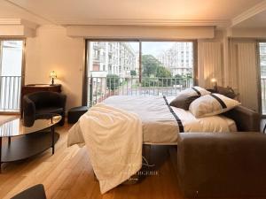 a bedroom with a large bed and a large window at L'Archimède - Parking privé in Versailles