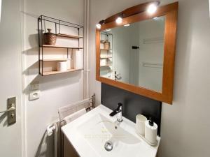 a bathroom with a sink and a mirror at L'Archimède - Parking privé in Versailles