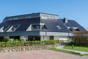 a large house with a black roof at Käpt'n Nelson, App 13 in Wenningstedt