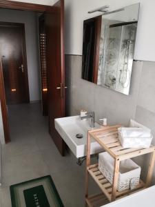 een badkamer met een wastafel en een spiegel bij I Corbezzoli in Porto Torres