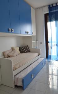 een bed in een kamer met blauwe kasten bij I Corbezzoli in Porto Torres
