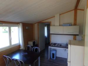 een kleine keuken met een tafel en stoelen in een kamer bij Terres de France - Les Hameaux de Miel in Beynat