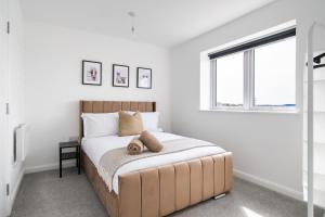 a bedroom with a bed with a large window at Brand New Luton Apartments in Luton